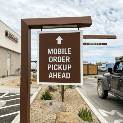 Brown mobile order pickup ahead sign outside of a newly-remodeled Chipotle restaurant.