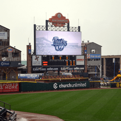 Field seating at Whataburger Field, the home field of the Corpus Christi Hooks baseball team. A colorful scoreboard surrounds stadium seats.