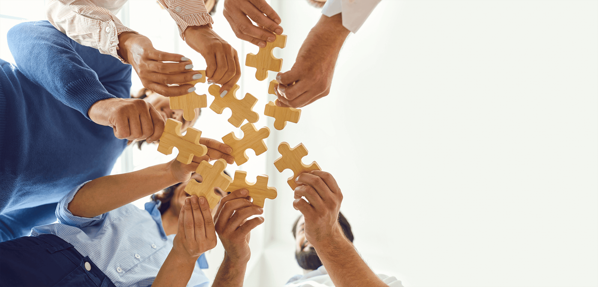 Hands with wooden puzzle pieces, illustrating a solution provider.