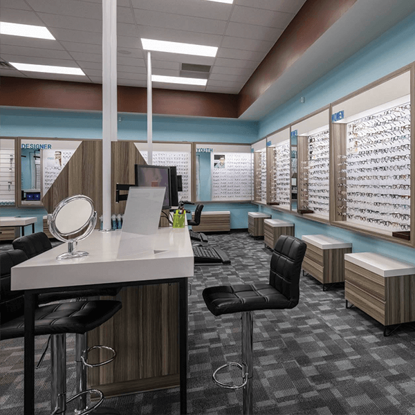 Interior of a newly designed My Eyelab store, with wood panels and glasses on display.
