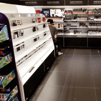 Left view of a white metal cosmetics cabinet inside a newly remodeled Sephora cosmetics store.