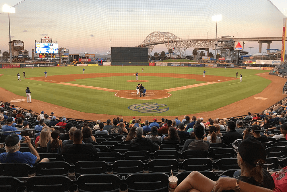 Home plate of Corpus Christi Hooks stadium in Texas, showing a happy crowd in the minor-league stadium.