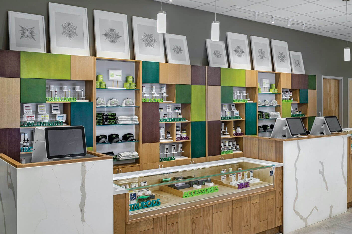 Interior of a new Trulieve cannabis store, showing all-natural design of green shaded walls, wooden counters and eco-focused artwork. 