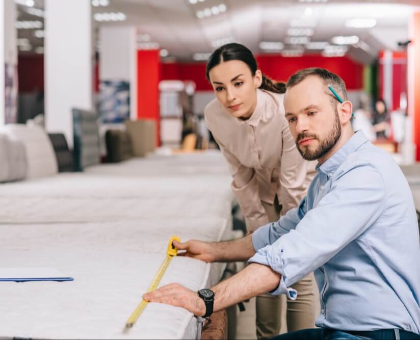DAVACO male employee wearing a blue business shirt, looking at architectural drawings with a businesswoman wearing a white button shirt.
