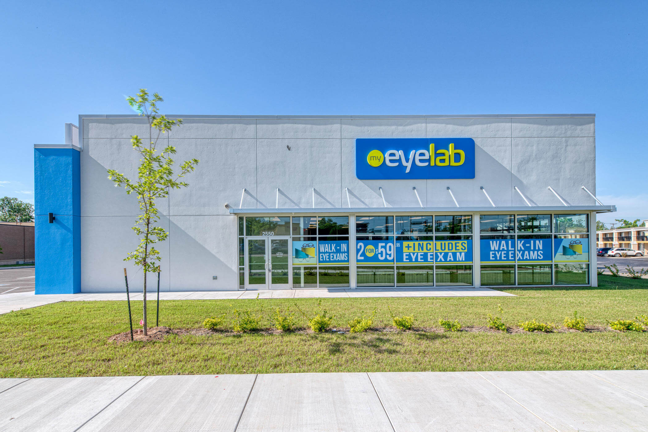 Exterior view of Stanton Optical EyeLab store, with large blue and yellow signage over floor to ceiling windows.