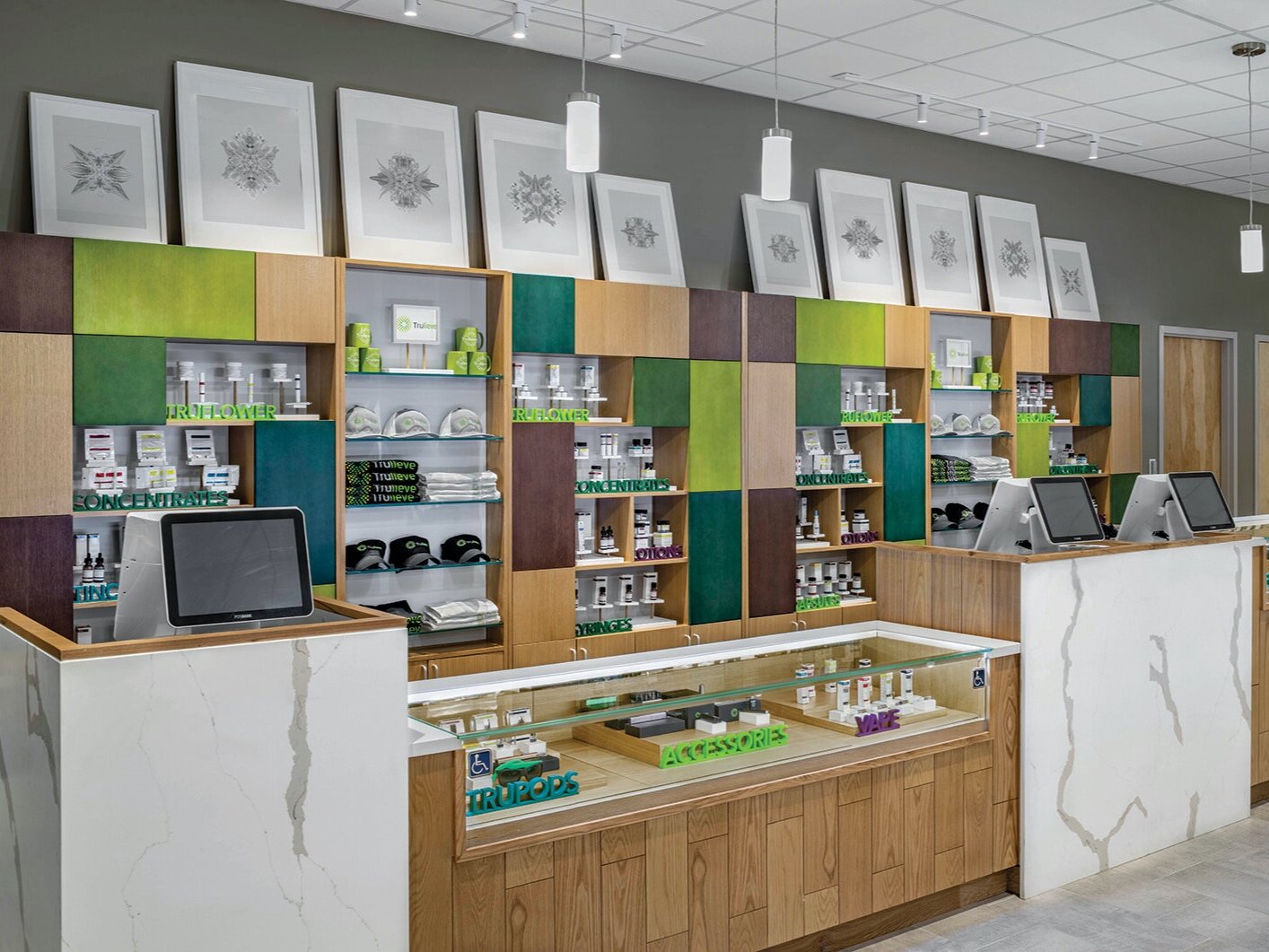 Interior checkout area of a Trulieve cannabis store. Each checkout has a marble front, is enclosed with glass and surrounded by wooden accents.